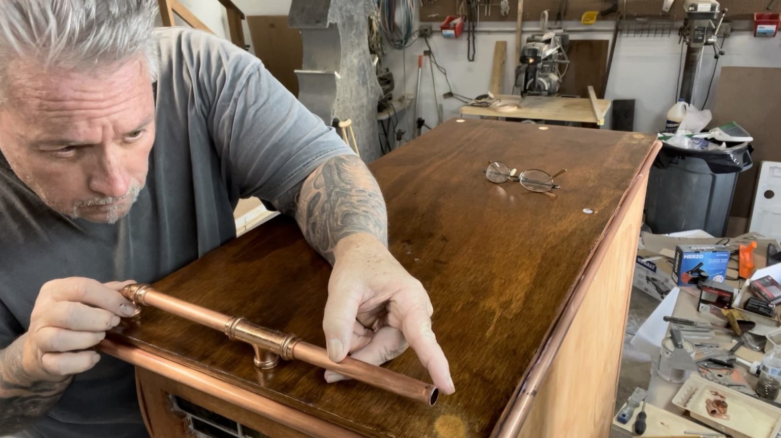 Man Placing Copper Accents On Furniture